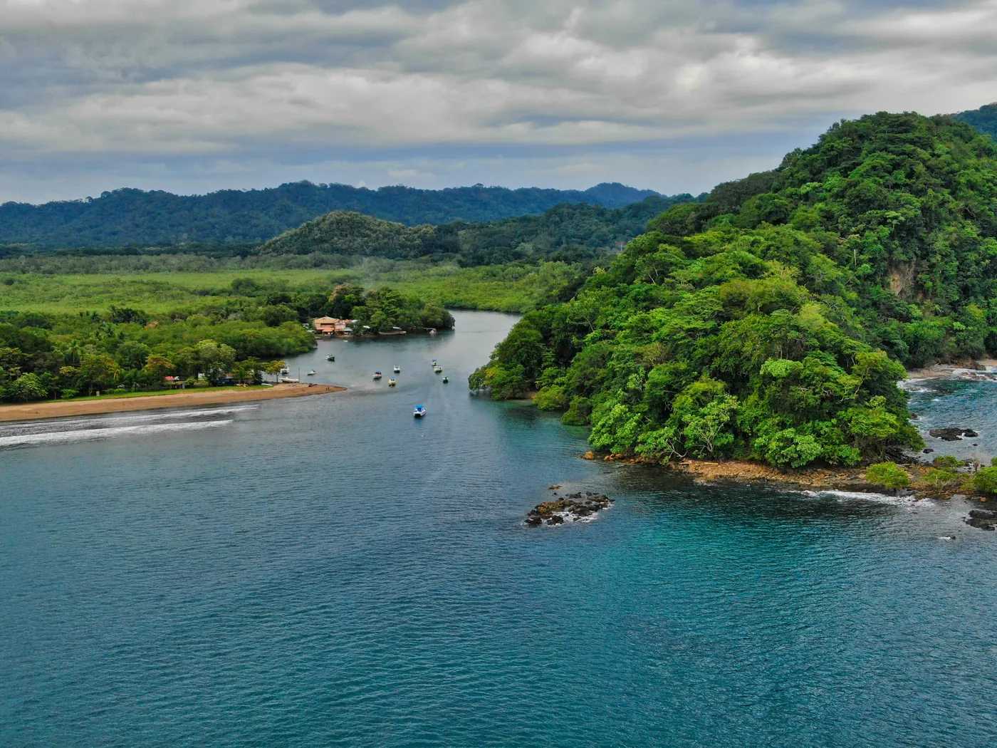 Coastal panga boats floating in calm turquoise water along the Nicoya Peninsula